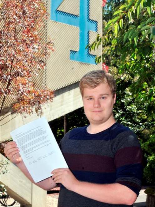 Second-year law student and class representative Daniel Doughty  holds a petition calling for...