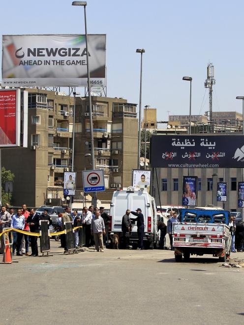 Security officials inspect the scene of a car bomb blast on a bridge in the Cairo district of...