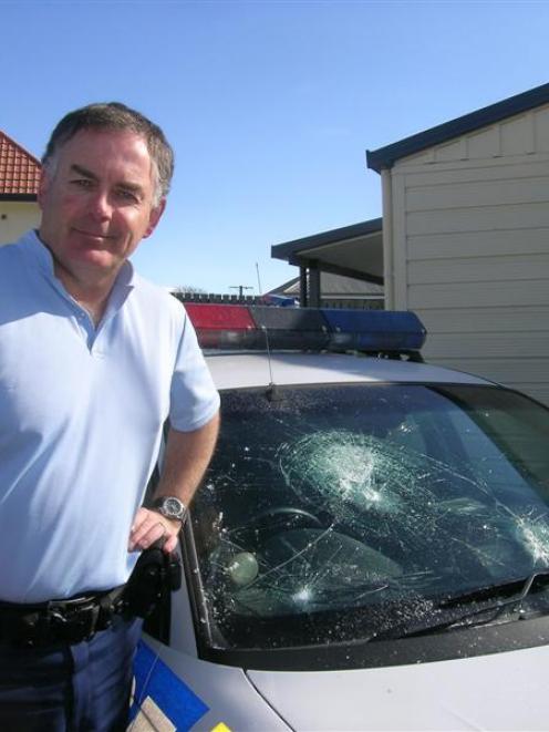 Senior Constable Ian Henderson, of Wanaka, next to a patrol car damaged outside a 16th birthday...
