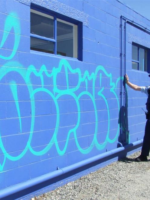 Senior Constable Mike Colligan shows tagging on one of two commercial premises hit on Saturday...