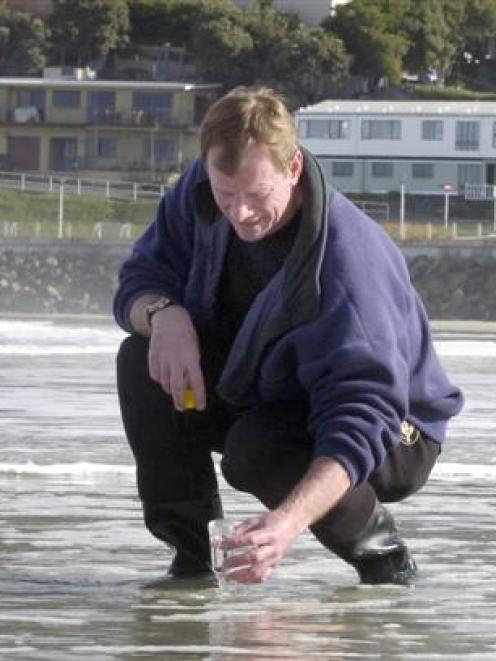 Senior environmental scientist Dr Brian Stewart takes water samples at St Clair beach, which,...