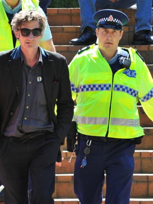 Senior Sergeant Craig Brown escorts a protester to a police car. Photo by Gerard O'Brien.