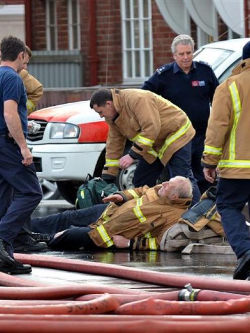 Senior Station Officer Lindsay Rae is supported by colleagues while he awaits medical treatment...