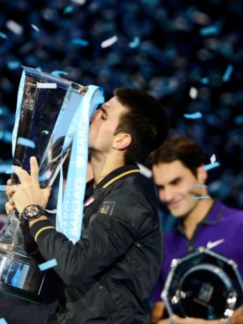 Serbia's Novak Djokovic kisses the trophy after beating Switzerland's Roger Federer in their...