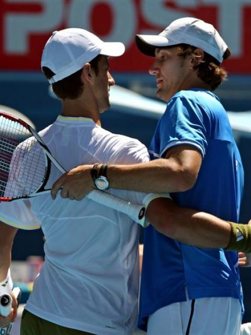 Serbia's Novak Djokovic, left, embraces Amer Delic of the United States at the net after beating...