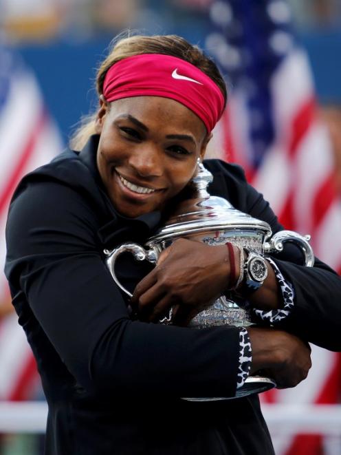 Serena Williams embraces the trophy after beating Caroline Wozniacki in their women's singles...