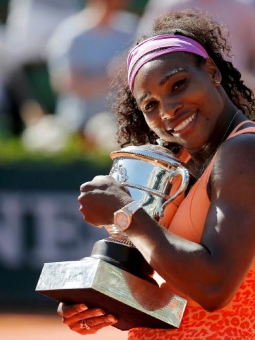 Serena Williams poses with the trophy after her win in the French Open at the Roland Garros...