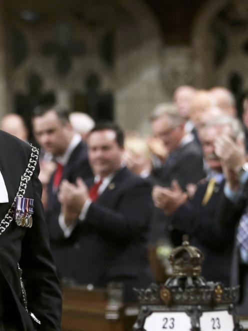 Sergeant-at-Arms Kevin Vickers is applauded in the House of Commons in Ottawa. Photo by Reuters