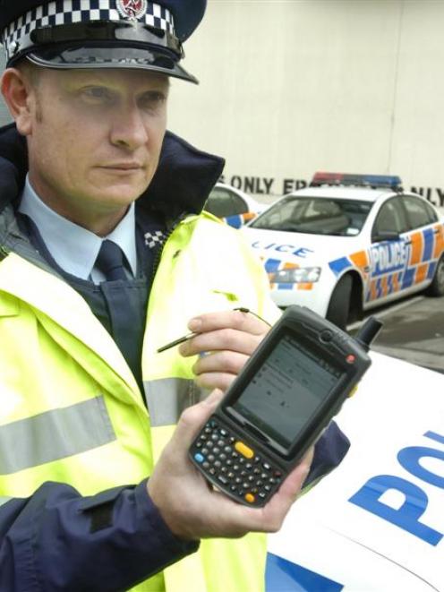 Sergeant Brian Yanko, of Wellington, displays an electronic ticketing device being used in trials...