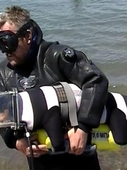 Sergei Gorbunov helps Boniface, the dachshund dog which is  learning how to scuba-dive in a...