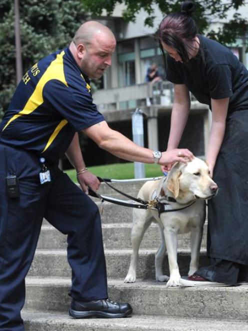 Simon Dixon, of Campus Watch, and Hayley Rawson hold the guide dog.