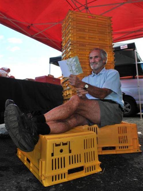 Sitting in front of crates that had been full of strawberries and cherries, Otago Farmers Market...