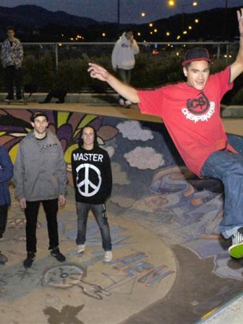 Skateboarder Chey Grace (21) shows his skill at the Dunedin Skateboard Park watched by (from left...