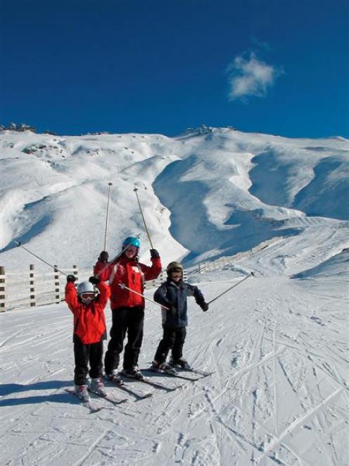 Skiers celebrate winter at Treble Cone yesterday after a run down the Saddle Basin.