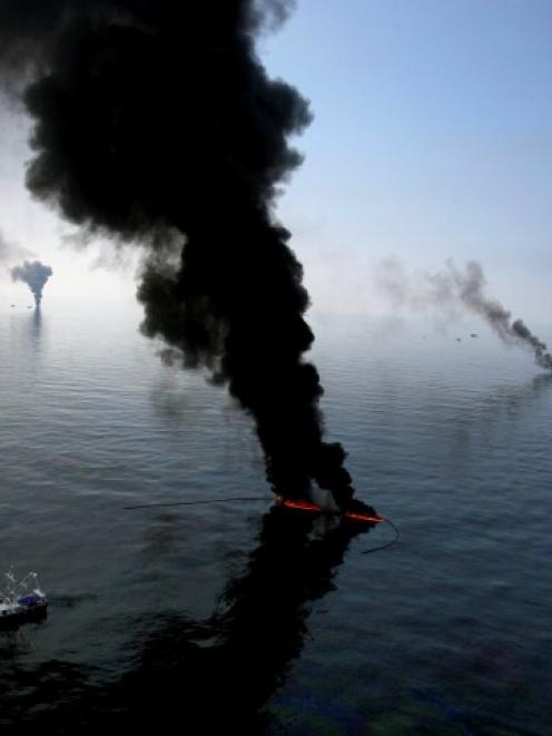 Smoke billows from a controlled burn of spilled oil off the Louisiana coast in the Gulf of Mexico...