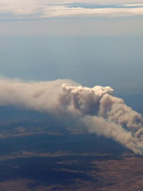 Smoke rises from the Yarrabin bushfire, burning out of control near Cooma, about 100km south of...