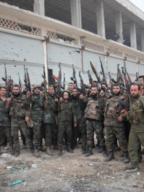 Soldiers loyal to Syria's President Bashar al-Assad pose for a photograph in the Aleppo town of...