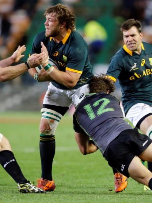 South Africa's Duane Vermeulen is tackled by the World XV's Roger Wilson (L) and Wynand Olivier....