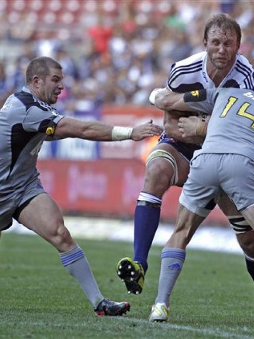 South Africa Stormers Andries Bekker, centre, is tackled by New Zealand's Hurricanes Cory Jane,...