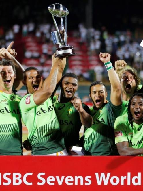 South African players celebrate with the trophy after winning the final of the Dubai Sevens....