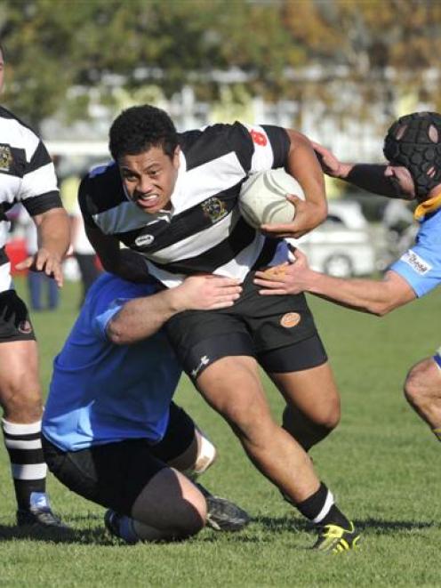 Southern flanker TJ Ioane is tackled by a  University A player (obscured) and lock Will Eder...