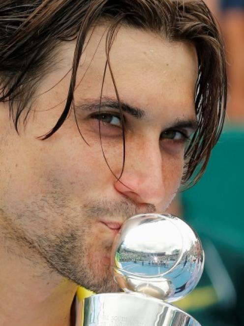 Spain's David Ferrer kisses the trophy after beating Germany's Philipp Kohlschreiber to win the...