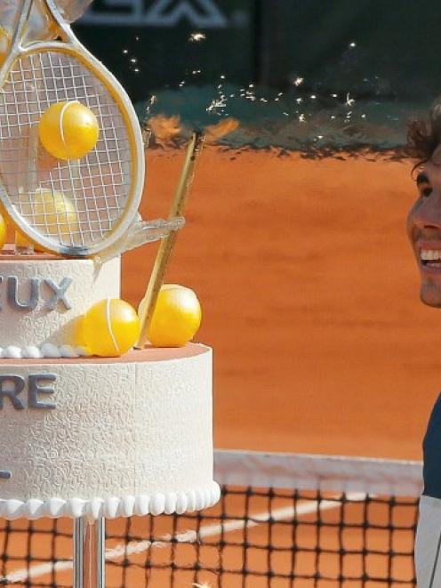 Spain's Rafael Nadal looks at his birthday cake after winning his men's singles match against Kei...