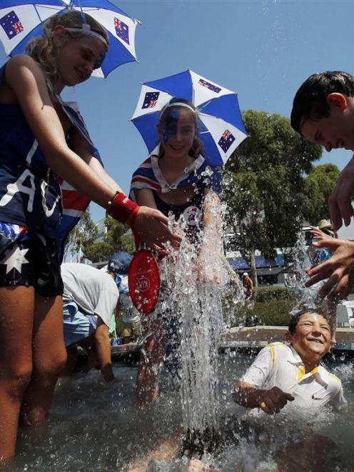 Spectators get into a fountain to cool off at the Australian Open tennis tournament in Melbourne....