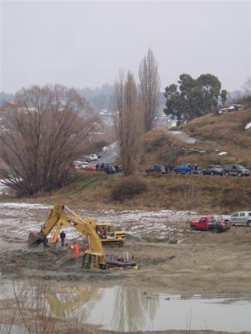 Spectators line the road to watch a 45-tonne excavator being retrieved from the Manuherikia River...
