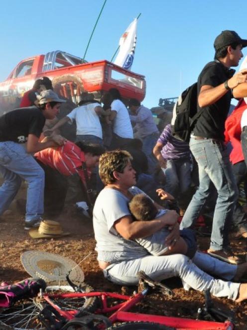 Spectators react after the monster truck rammed the stand where they were watching at El Rejon...