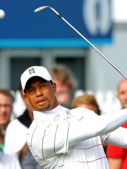 Spectators watch as US golfer Tiger Woods hits shots during a practice round ahead of the British...