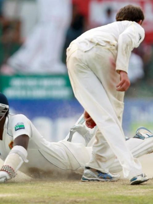 Sri Lanka's Angelo Mathews dives to complete a run as Australia's Nathan Lyon breaks the wickets...