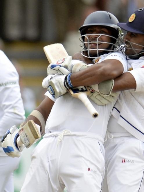 Sri Lanka's Kumar Sangakkara is embraced by team mate Mahela Jayawardena (R) after Sangakkara...