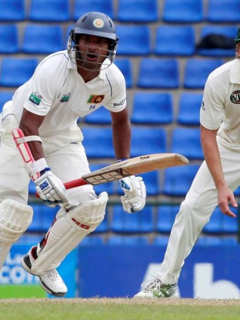 Sri Lanka's Kumar Sangakkara watches his shot as Australia's Shane Watson looks on during the...