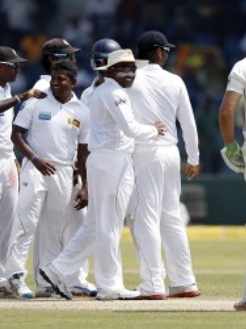 Sri Lanka spinner Rangana Herath (centre) celebrates with team-mates after having New Zealand's...