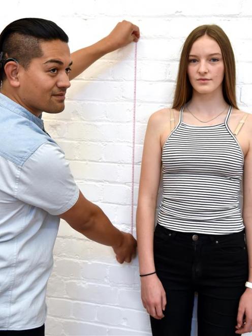 St Hilda’s College pupil Clem George (15) is measured by Otago Polytechnic fashion design student...