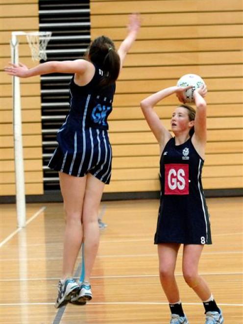 St Hilda's goal keep Zara Overton leaps high to block a shot from Columba College goal shoot...