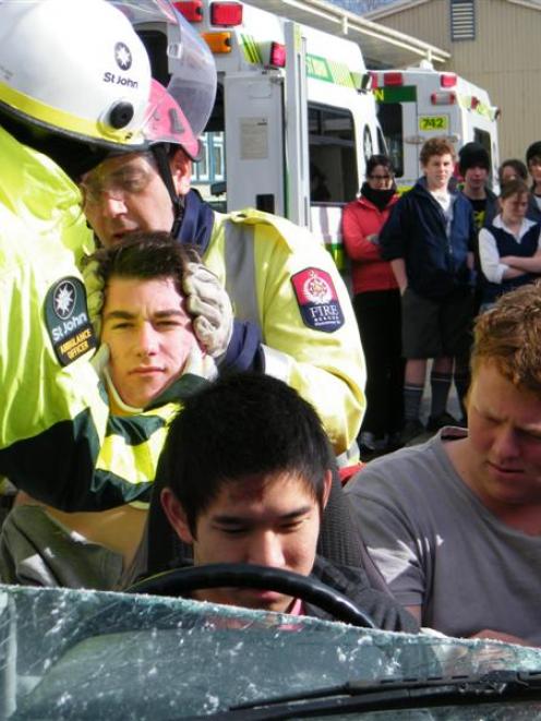 St John ambulance crew  and fire officer Geoff Finney (right) hold "patient" Jack Dobbie's head...