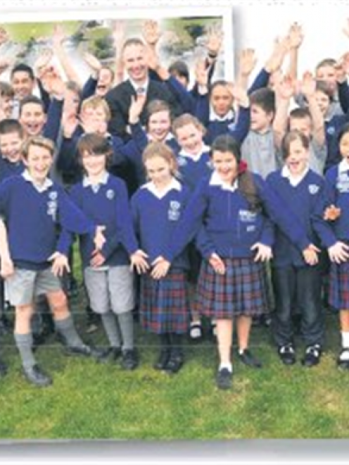 St Mary's School principal Mike Brosnahan and pupils celebrate on the Mosgiel site where their...
