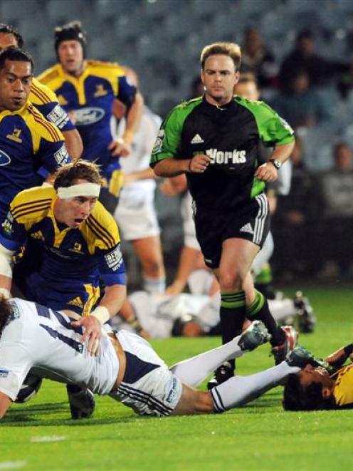 Stormers player Peter Grant is tackled by Jimmy Cowan and Mathew Berquist in the Super 14 rugby...