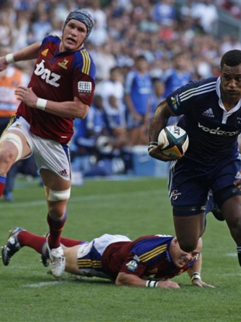 Stormers player Sireli Naqelevuki, right, runs with the ball as  Highlanders players give chase. ...