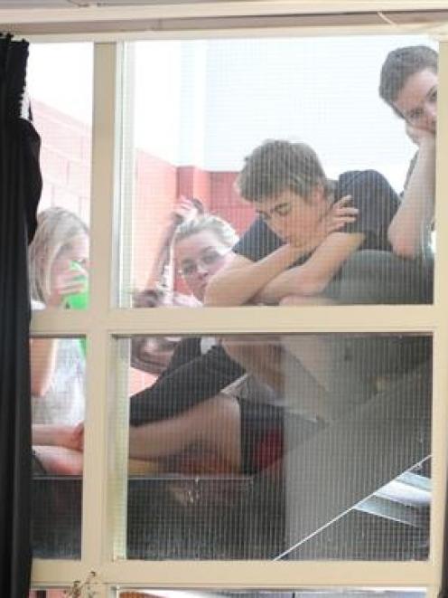 Students cling to the fire escape to listen to Prime Minister Helen Clark. Photo by Craig Baxter.