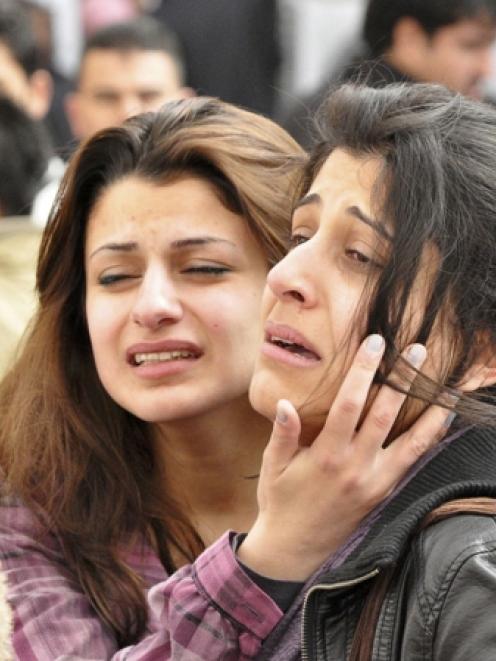 Students grieve after a fellow student shot dead his American teacher at a school in Sulaimaniya,...