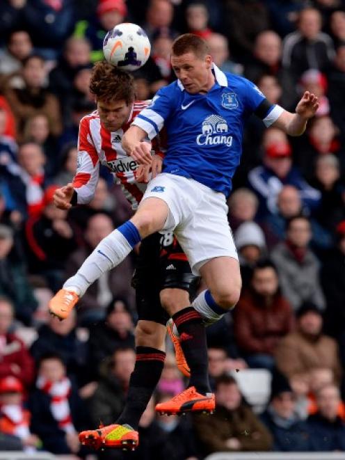 Sunderland's Marcos Alonso (L) challenges Everton's James McCarthy. REUTERS/Nigel Roddis