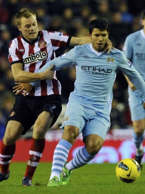 Sunderland's Sebastian Larsson (L) challenges Manchester City's Sergio Aguero during their...