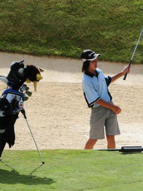 Sungwoo Han (13), of Queenstown, plays from the bunker during his round on The Hills course in...