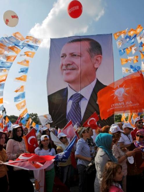 Supporters hold a poster of Turkish Prime Minister Tayyip Erdogan during a mass rally in Istanbul...