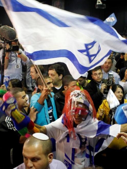 Supporters of Prime Minister Benjamin Netanyahu's Likud party celebrate after the exit polls were...