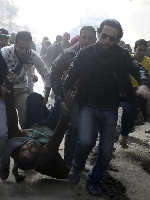 Supporters of the Muslim Brotherhood and ousted Egyptian President Mohamed Mursi carry an injured...