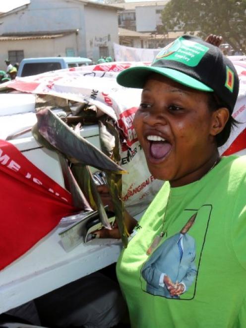 Supporters of ZANU-PF party celebrate with a coffin wrapped in a Movement for Democratic Change...